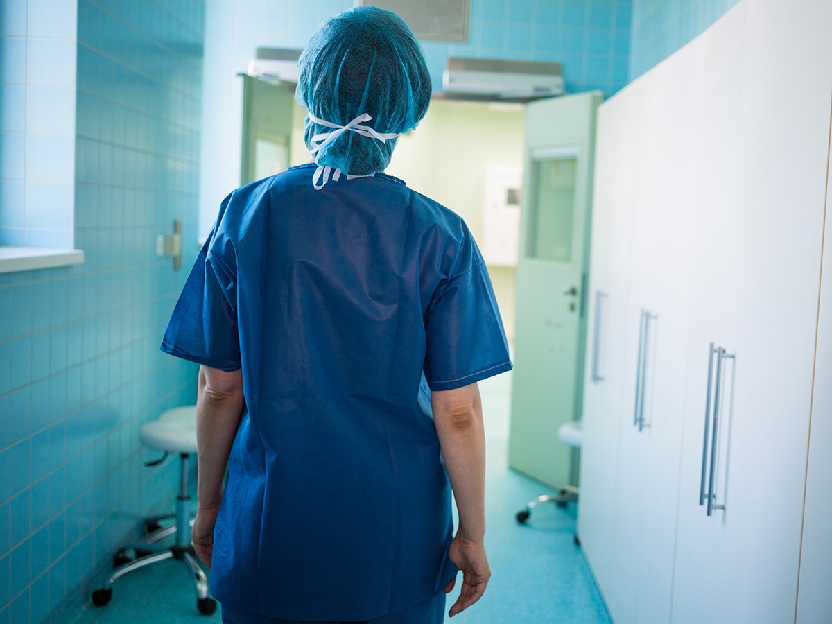 Enfermera camina por pasillo de un hospital